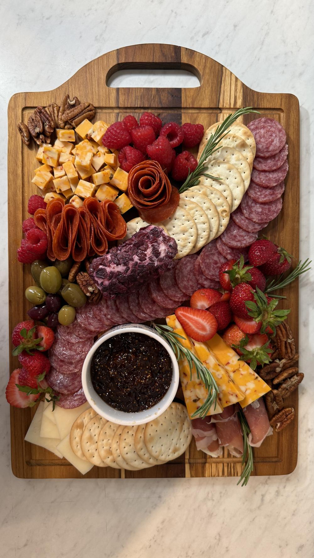 Signature Miora Cheese board ready for delivery, with cheeses, berries and a salami rose