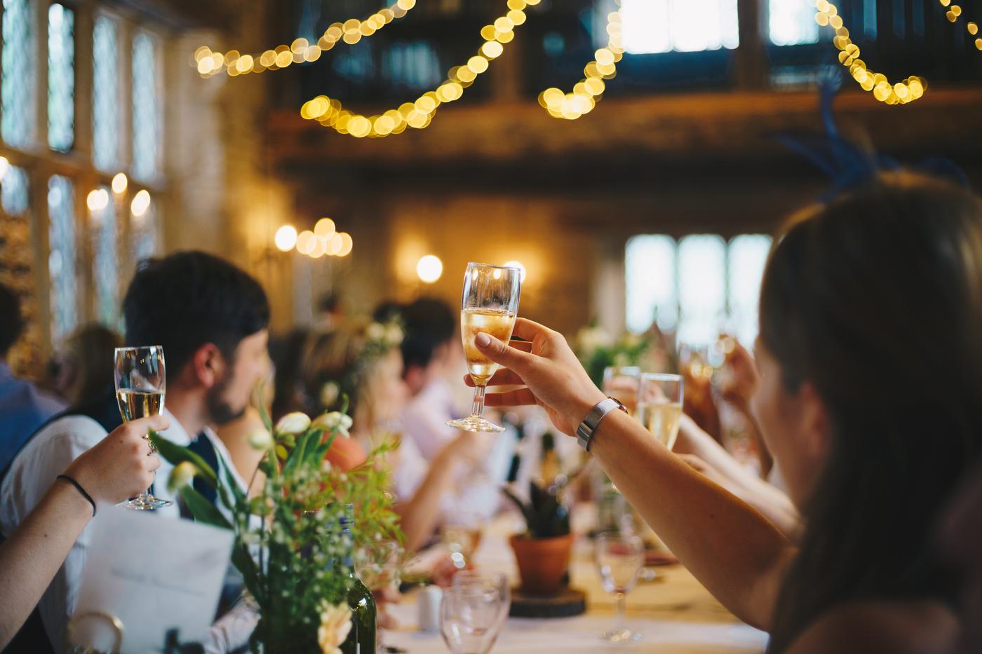 Guests raising champagne glasses at an elegant catered celebration