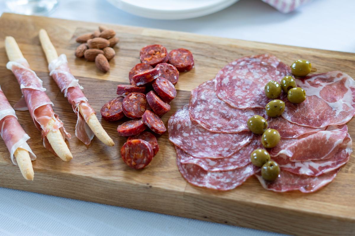 Cured meats, olives and almonds styled on a board for inflight service